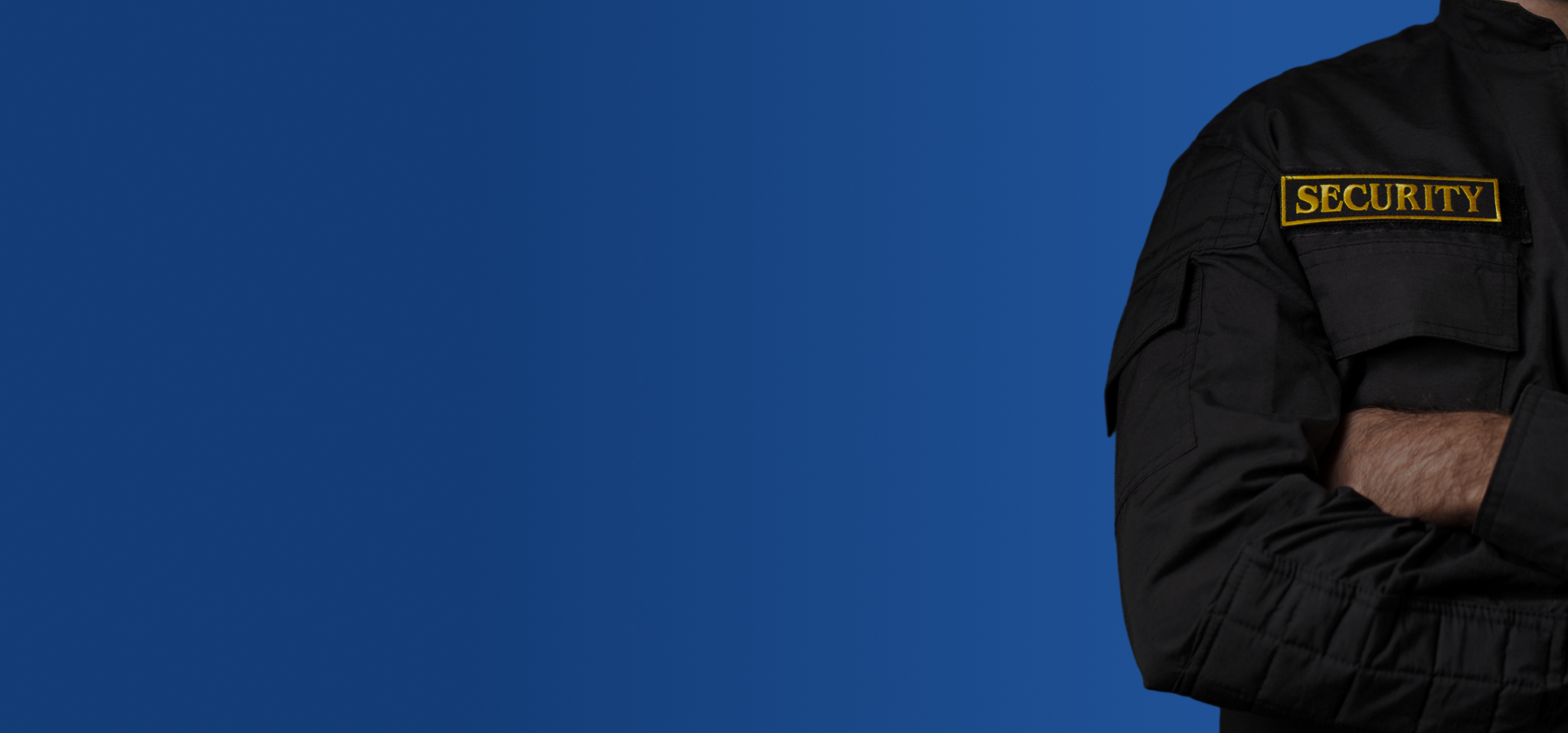 Sicherheitsdienstmitarbeiter mit verschränkten Armen vor blauem Hintergrund
